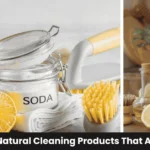 Best natural cleaning products including vinegar, baking soda, castile soap, and essential oils arranged with reusable spray bottles on white kitchen counter