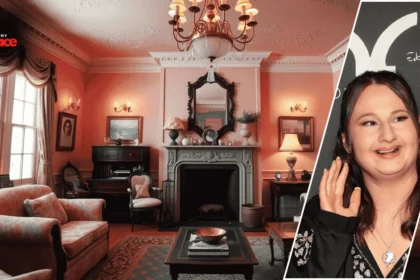 Image showing the gypsy rose pink house with its bright pink exterior in the background and a framed portrait of the owner displayed at the front.