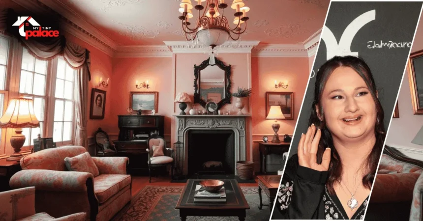 Image showing the gypsy rose pink house with its bright pink exterior in the background and a framed portrait of the owner displayed at the front.