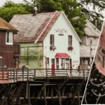 An exterior view of dolly's house museum with the historic home in the background and a framed portrait of Dolly Parton displayed at the front