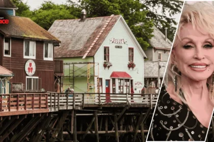 An exterior view of dolly's house museum with the historic home in the background and a framed portrait of Dolly Parton displayed at the front