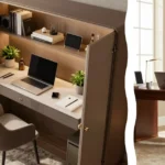 A polished brass door hinge in sharp focus with a sleek monitor, integrated cable management track, and a minimalist keyboard inside a newly completed convert armoire to tech center project blurred in the background.